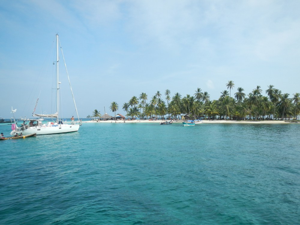 A boat floats off the coast of Isla Perro Beach in San Blas, Panama