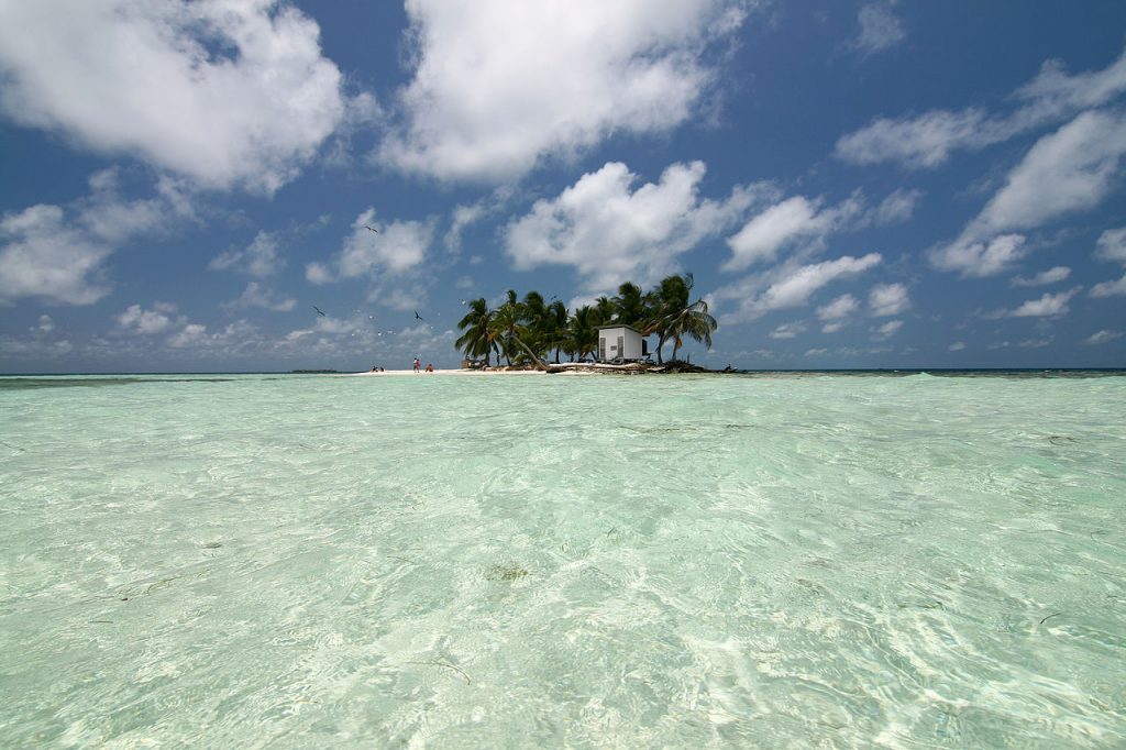 The remote beach of Silk Cayes can be seen from the point of view of a nearing boat that brings visitors