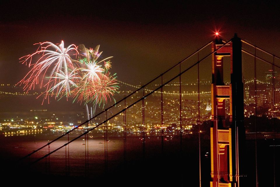 The fireworks on the 4th of July are sent up to the air from behind the Golden Gate Bridge