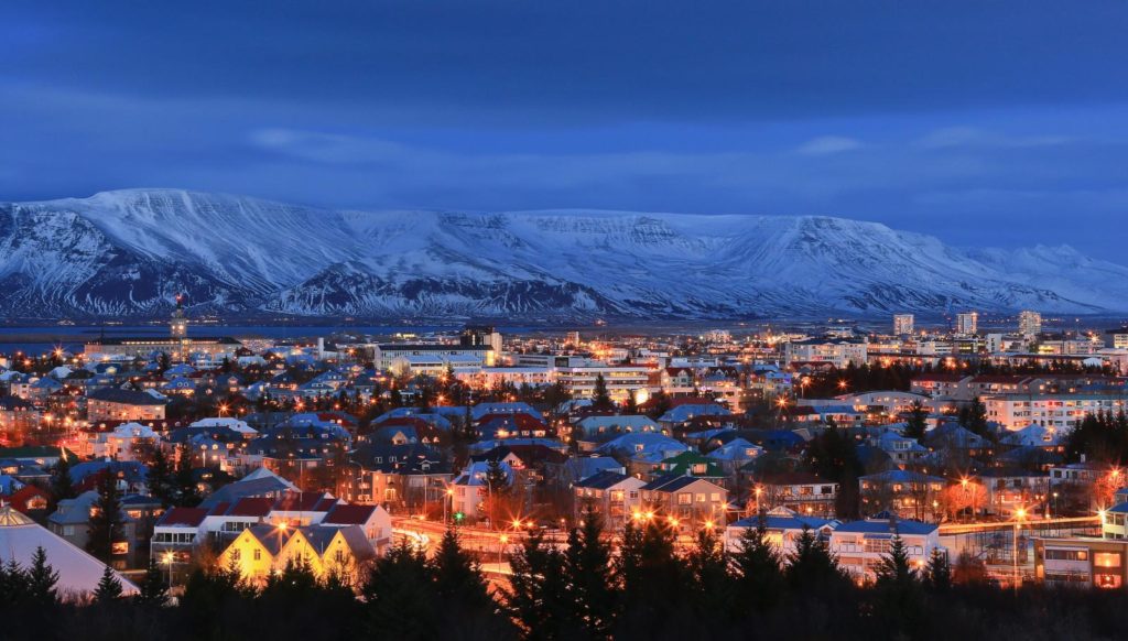 A snow-covered mountain encircles the city of Reykjavik