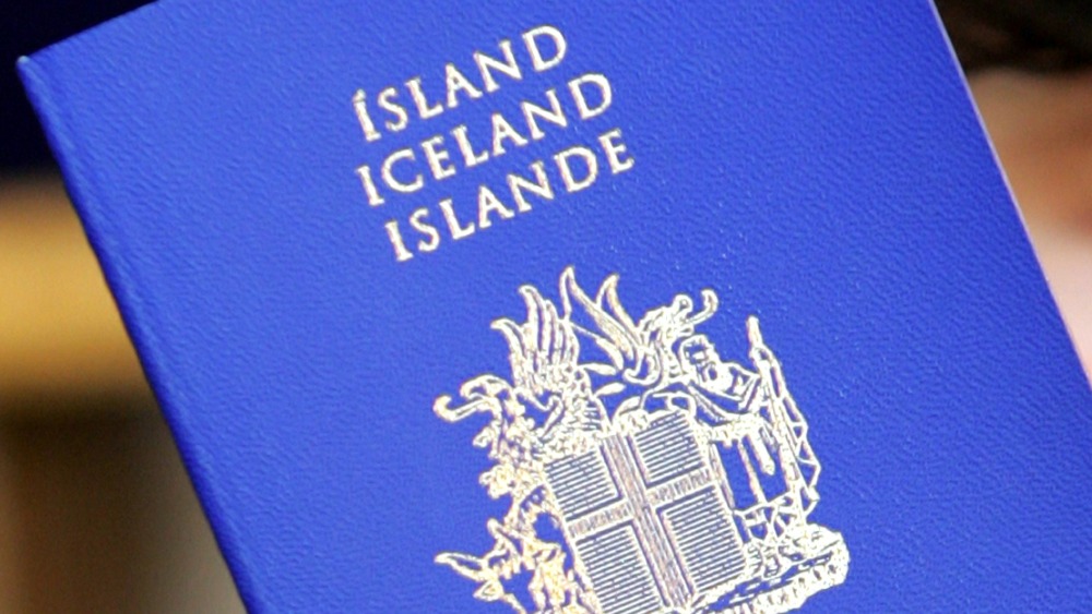 A person holds up a passport of Iceland