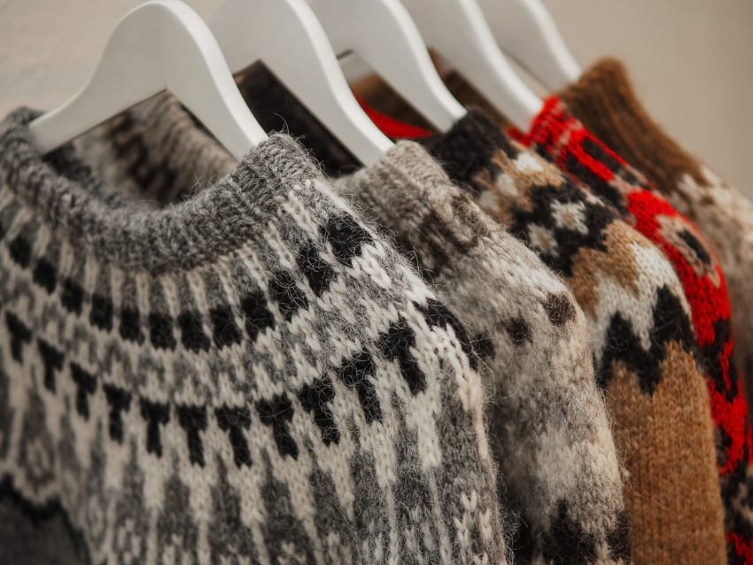 Several hangers displayed side by side holding up Icelandic sweater made from wool